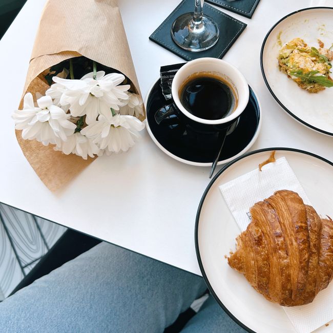 Croissant et tasse de café dans la lumière du matin.
