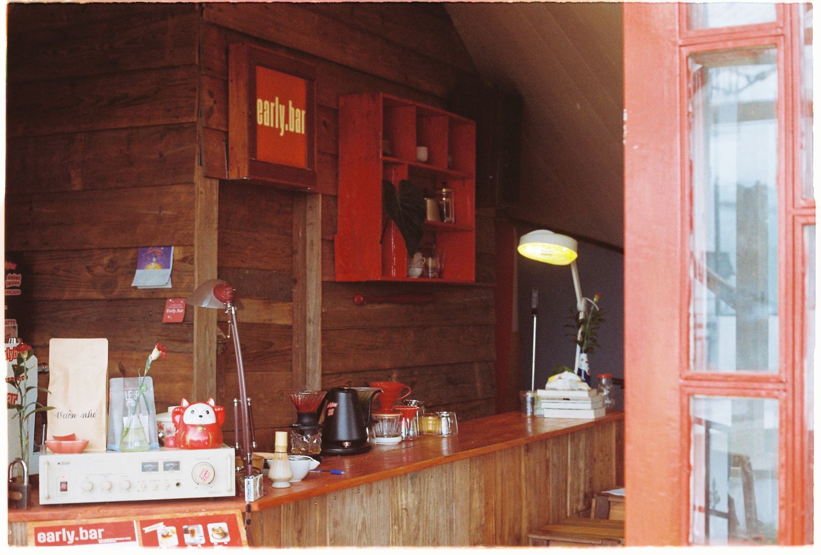 Intérieur chaleureux d'un café en bois avec comptoir et tablettes.