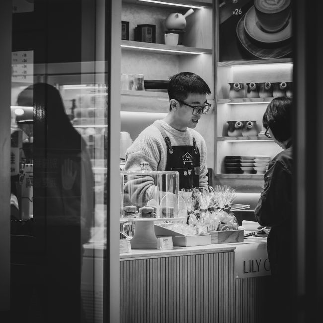 Tablette d'épicerie d'un café avec sacs de grains et produits locaux.